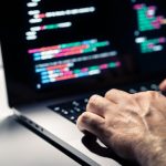 Hacker,With,Malware,Code,In,Computer,Screen.,Cybersecurity,,Privacy,Or